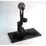 A large Art Deco style brown patinated bronze semi-clad exotic dancing girl with ball (