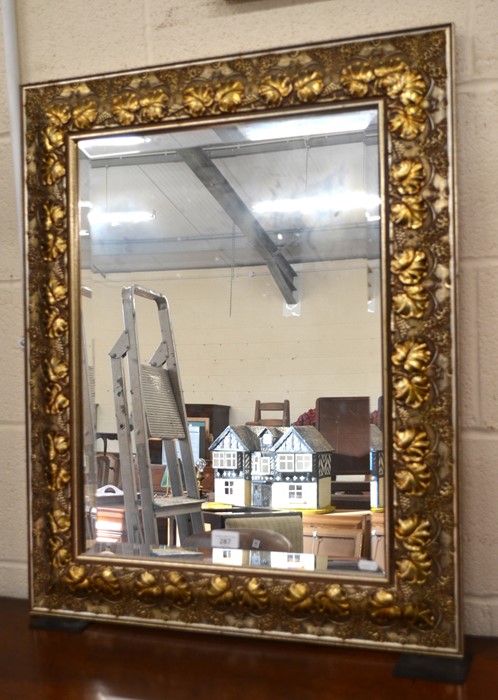 A rectangular bevelled wall mirror in foliate carved gilt frame