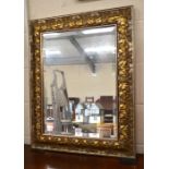 A rectangular bevelled wall mirror in foliate carved gilt frame