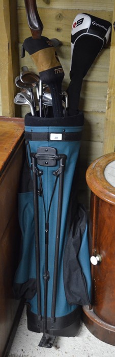 A set of Taylormade golf clubs to/w green golf bag with folding stand