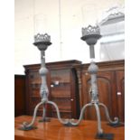 A pair of grey painted wrought metal candle stands with foliate decoration