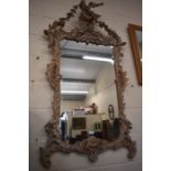 A foliate carved Chippendale style wall mirror surmounted by a bird