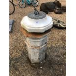 A 17th century style sundial mounted on a alabaster base and raised on a terracotta chimney pot