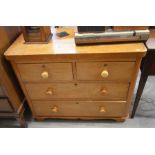 A small Victorian chest of two short over two long drawers with turned pulls raised on low bracket