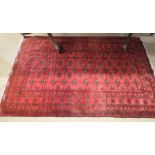 An Indo-Persian Turkoman design rug with linked geometric guls on red ground within multi border