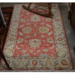 A Pakistani made Farhan wool rug with scrolling floral design on brick ground with camel border