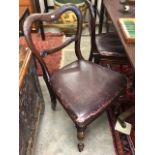 A set of four rosewood and mahogany balloon back dining chairs with faux leather upholstery