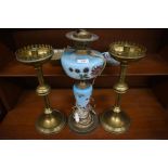 A pair of tall brass candle holders and a Victorian floral painted opaque glass oil lamp (