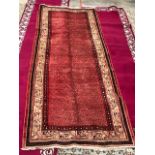 A Persian Arak runner with repeating boteh design on red ground within guarded border 310x110cm [1]