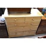 A large stripped pine chest of two short over three long drawers with turned pulls, raised on bun