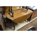 French pine drop leaf dining table raised on turned supports with castors