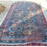 A heavily worn Persian navy ground rug with geometric guls on navy ground, repeating multi borders