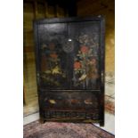 An antique Chinese black lacquer cabinet with pair of hinged doors centred by a metal lock,