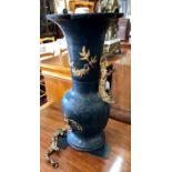 A Chinese style metal vase with foliate rim and wave-design handles, decorated in gilt relief with a