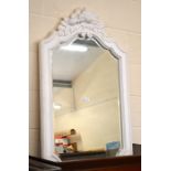 A cream painted wall mirror with foliate decoration and bevelled mirror plate