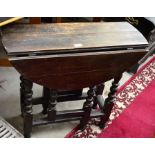 A small 19th century oak drop leaf table on gateleg action supports