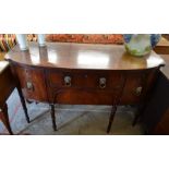 A Georgian mahogany bow front sideboard with brass lion mask handles and slender turned supports