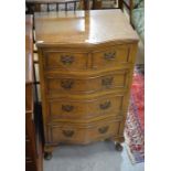 A Georgian style walnut serpentine front chest of four long drawers raised on short cabriole