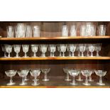 A suite of cut drinking glasses with facetted stems including twelve champagne saucers