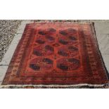 A Turkoman red ground rug with eight large geometric guls within repeating borders 160 x 129 cm