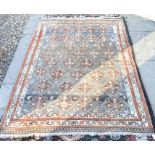 A Turkish wool rug, the central reserve with red diamonds on abrashed blue ground within ivory