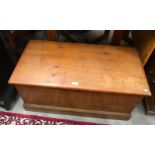 An antique scumbled pine blanket chest with hinged top and fitted internal drawer