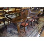 Early 20th century mahogany extending dining table, the rounded rectangular top with three central