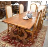 A Continental rectangular light oak dining table with a cleated and panelled top raised on shaped