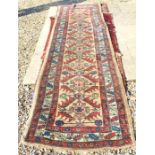 A worn camel ground Persian runner with stylised design and palmette guarded border 335 x 93 cm