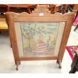 A mahogany framed fire screen with glazed wool tapestry panel of lady in crinoline dress