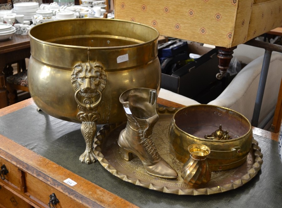 A large brass log bin with lion mask embellishment on paw feet, a brass jardinière, spill holder