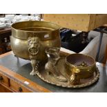 A large brass log bin with lion mask embellishment on paw feet, a brass jardinière, spill holder