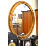 A bronzed oval wall mirror