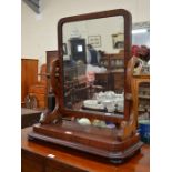 A large Victorian toilet mirror on shaped supports and platform base raised on turned bun feet
