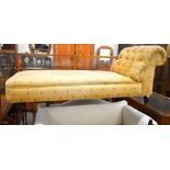 A mahogany framed scroll end chaise longue with yellow floral buttoned upholstery raised on turned