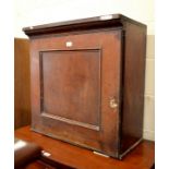 A 19th century mahogany hanging wall cupboard with pigeonhole fitted interior enclosed by a single