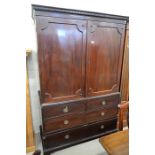 A Victorian mahogany linen press with panelled doors enclosing five slides over a base with two