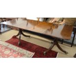 A Regency style extending mahogany dining table with two central leaves on twin pedestal supports
