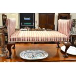 A Victorian mahogany framed window seat with striped floral silk upholstery raised on pad footed