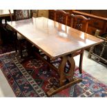A small oak refectory dining table with rectangular top raised on shaped trestle supports united