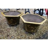 A pair of weathered octagonal Japanese glazed terracotta garden urns, raised on six moulded feet (