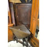 An oak corner cupboard on stand with single panelled door to/w a small oak drop leaf table on turned