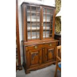 Edwardian mahogany chiffonier bookcase with a pair of glazed doors over two drawers and carved