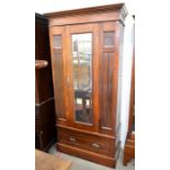 An Edwardian mahogany wardrobe, the panelled front with carved decoration centred by a mirrored door