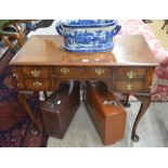 A walnut crossbanded dressing table, the five drawers with bass handles raised on pad footed