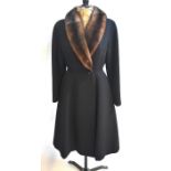 A Dereta black wool gabardine fitted coat with single button fastening and brown mink collar, 50