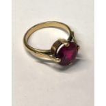 A yellow metal ring with circular single red stone, claw set, size N/O, approx 3.9g