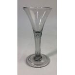 An 18th century wine glass, drawn trumpet bowl, plain stem with full length tear drop, domed