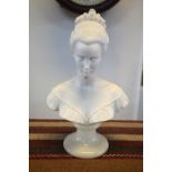 A small marble bust of a young lady with ornate hair-do, signed A. Grimmelli (?), on alabaster socle