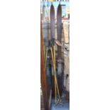 A pair of vintage wooden skis with leather strap bindings, to/w a pair of bamboo ski-poles with